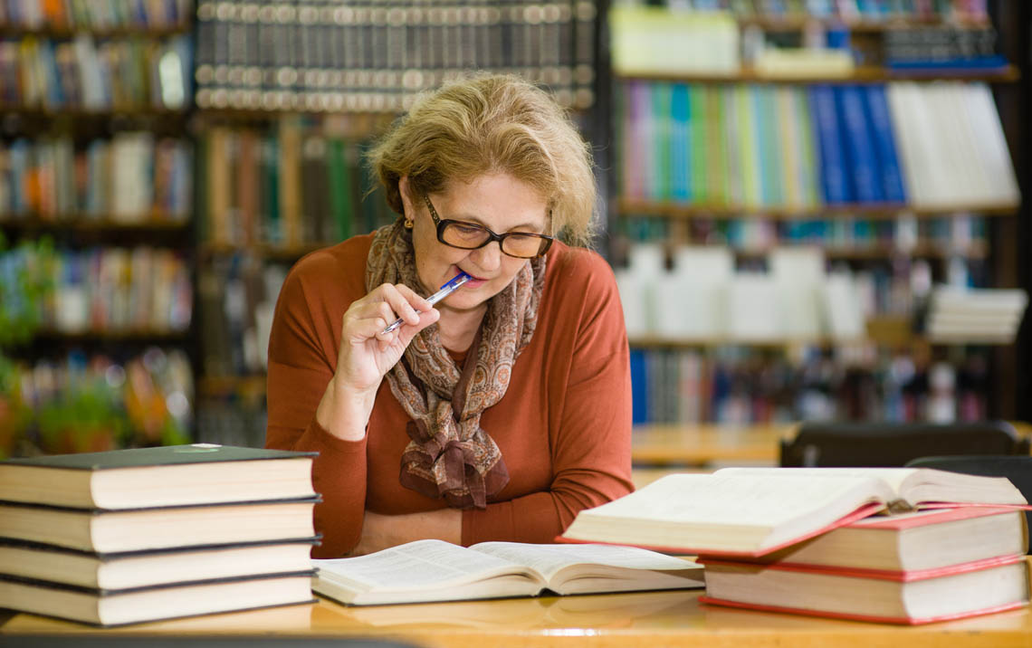 Ältere Frau lernt eine Sprache in der Bibliothek
