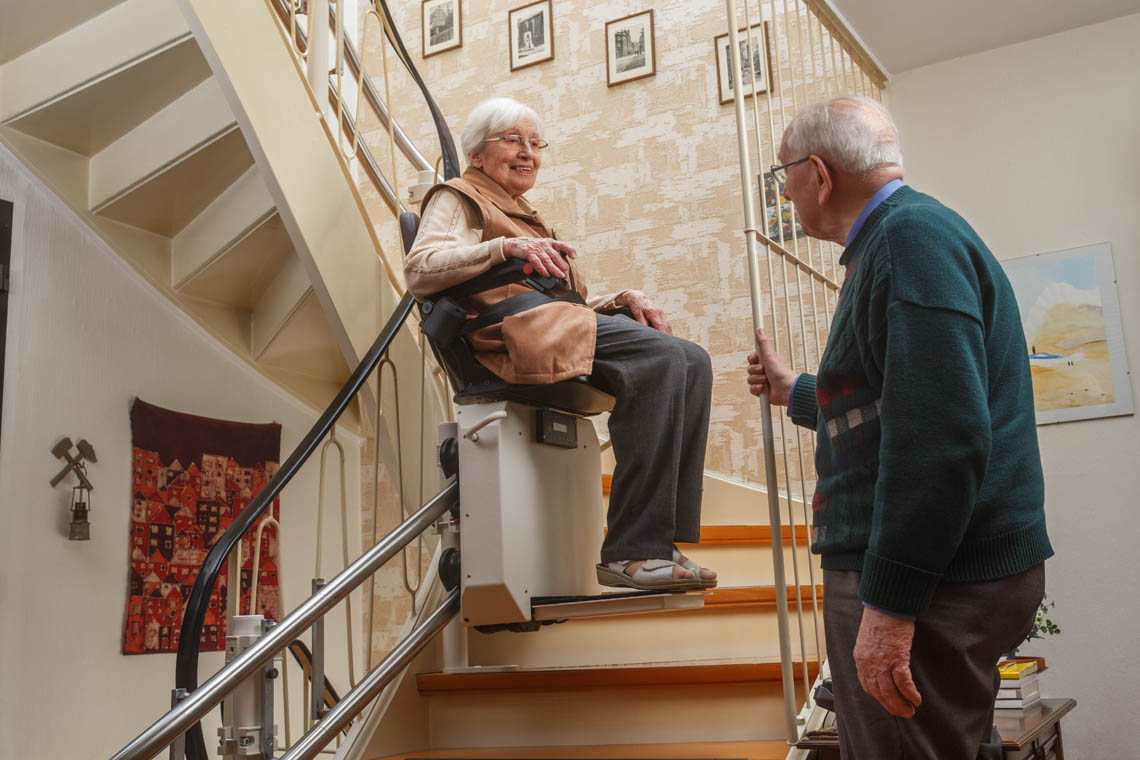 Seniorin benutzt Treppenlift