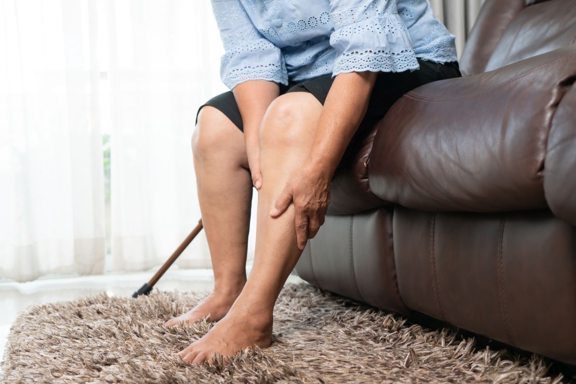 Was hilft gegen schwere Beine: Frau hält schmerzende Beine