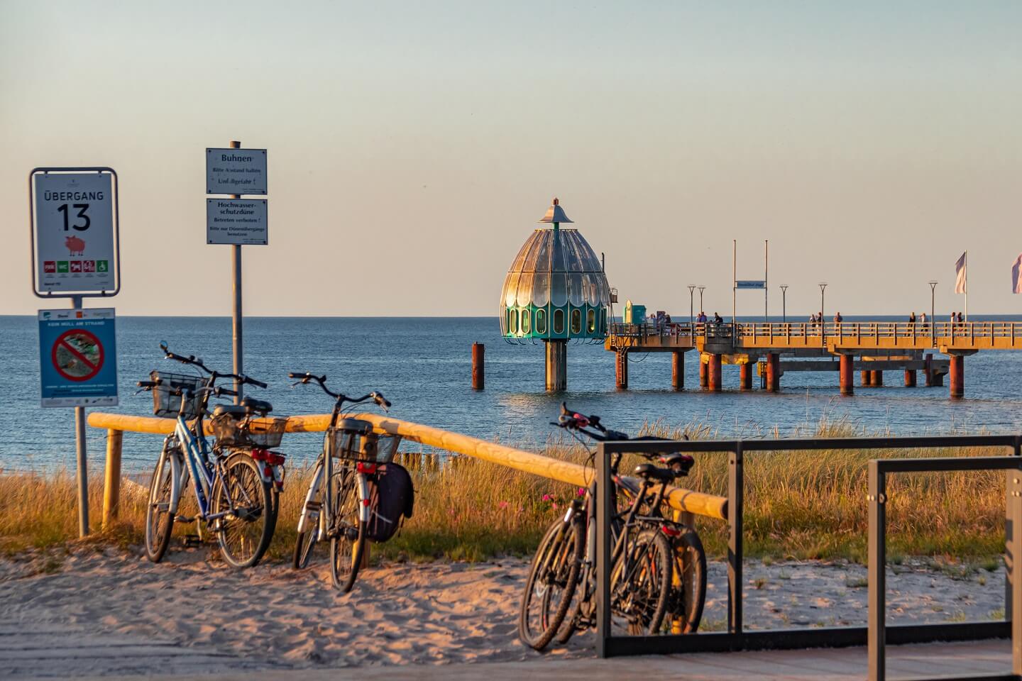 Strand mit Fahrrädern und Blick auf den Pier in Zingst