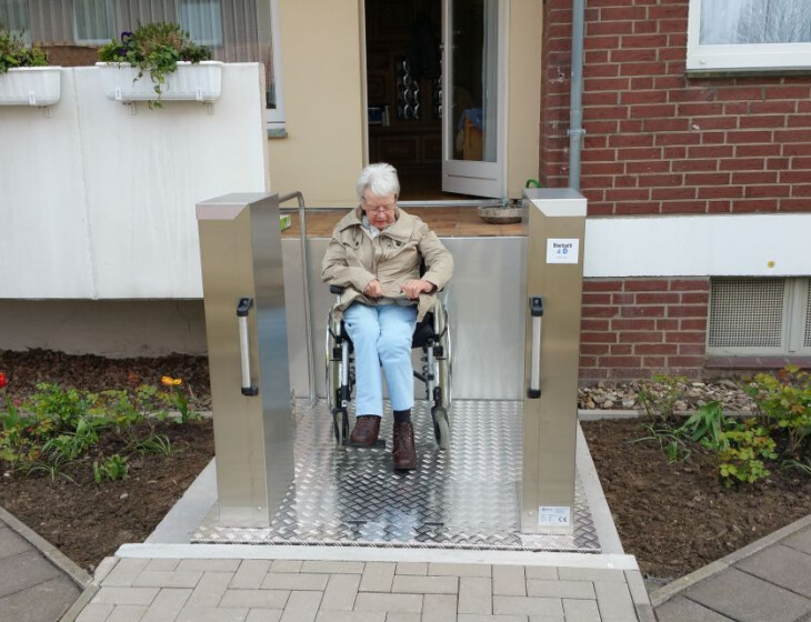 Seniorin im Rollstuhl benutzt Hublift