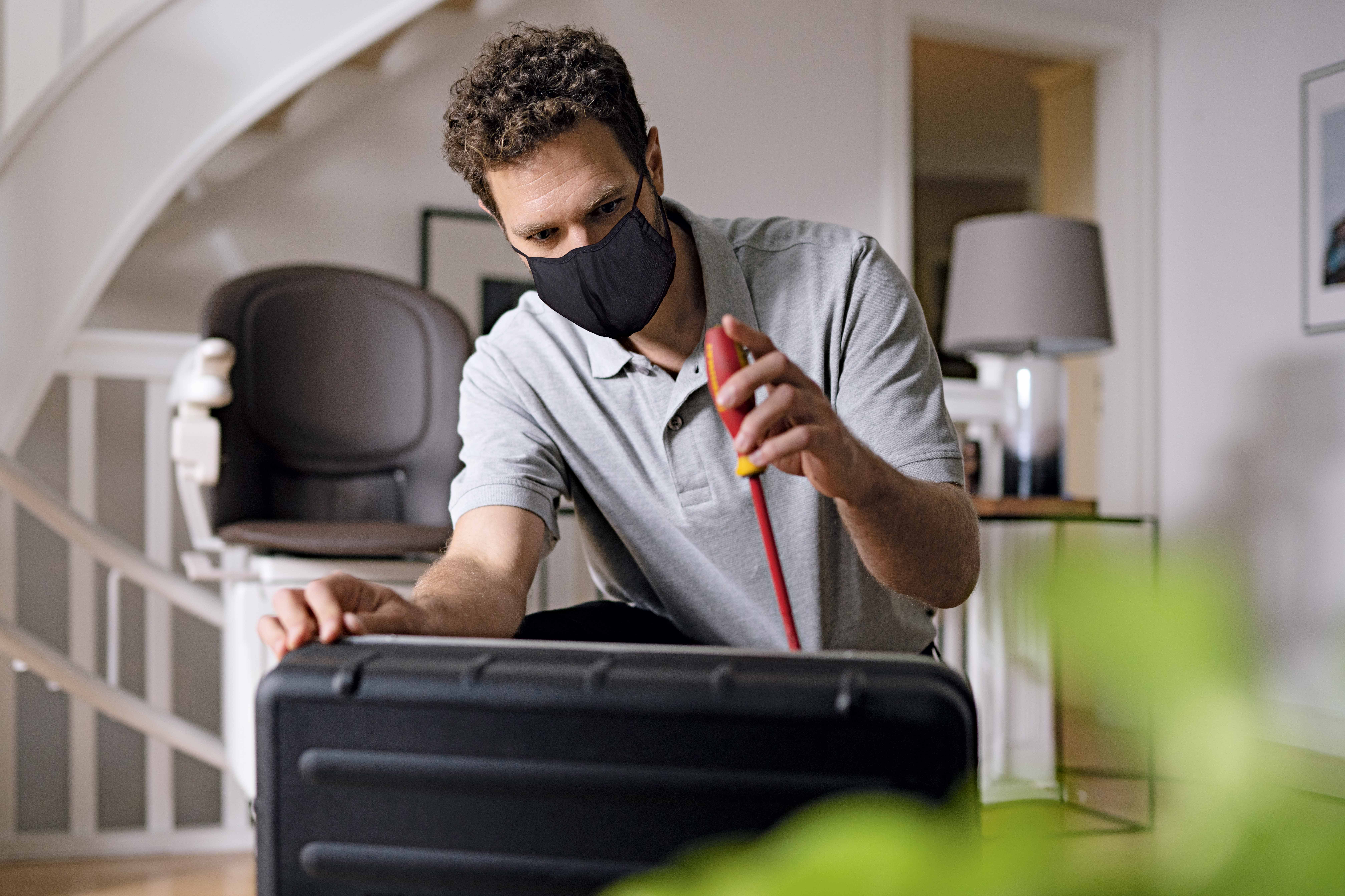 Service bei Lifta: Techniker mit Mundschutz installiert Treppenlift