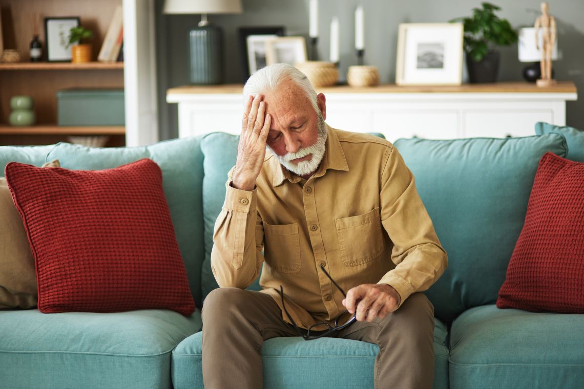 Altersdepression: trauriger Mann sitzt auf Couch