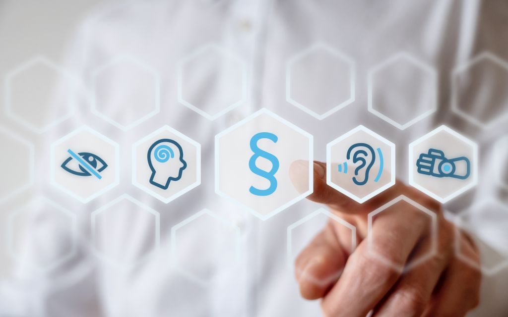 Verschiedene Icons zur Darstellung von Barrierefreiheit. Ein Finger zeigt auf das Icon mit Paragraphen-Symbol