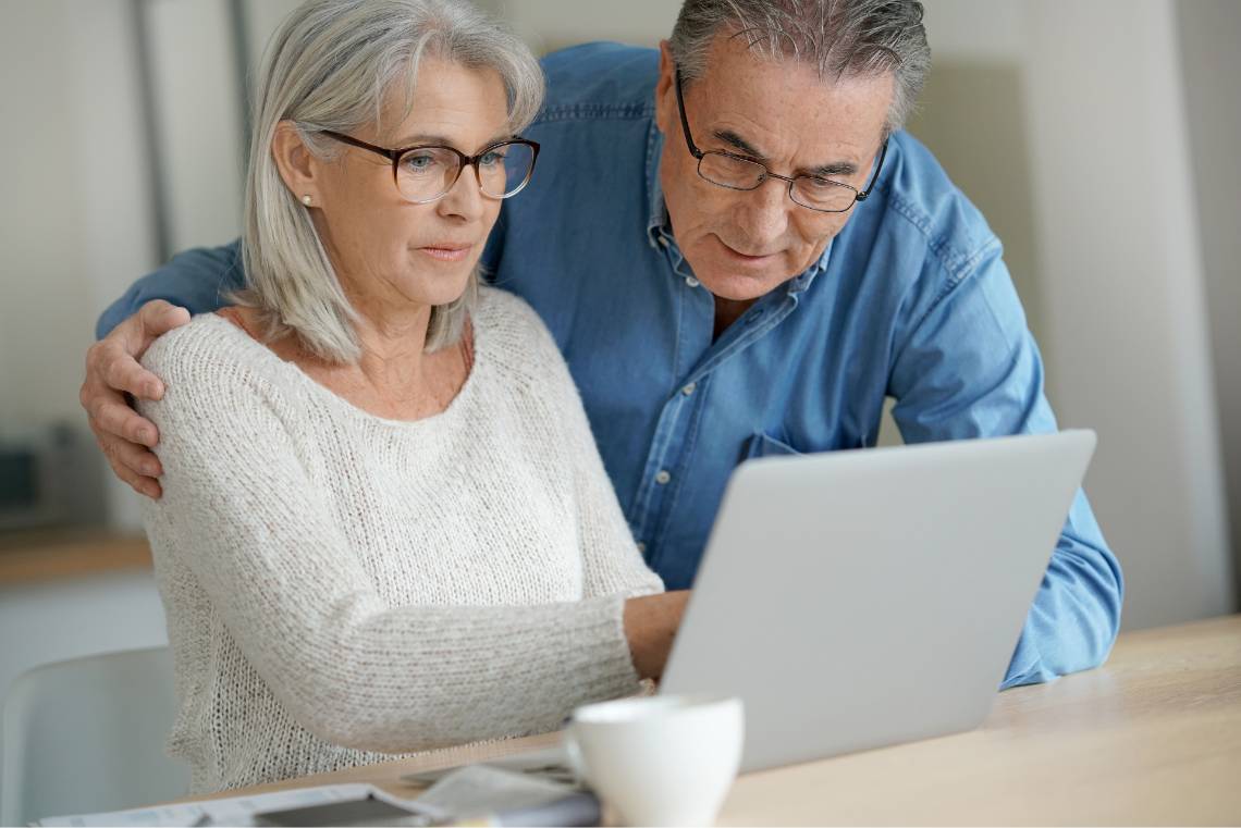 Ehepaar schaut gemeinsam auf den Laptop