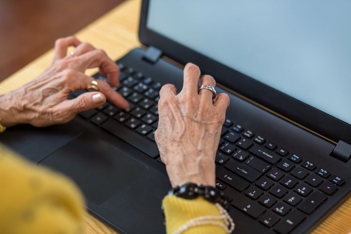 Alte Dame tippt auf dem Laptop