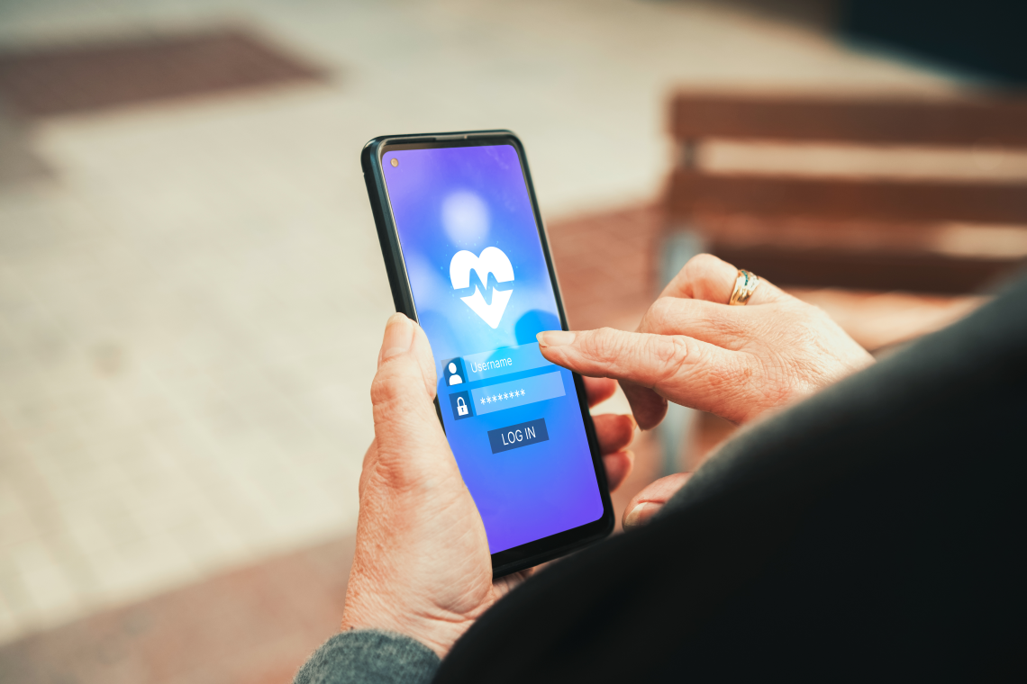 Nahaufnahme einer älteren Person, die auf einem Smartphone eine Gesundheits-App bedient.