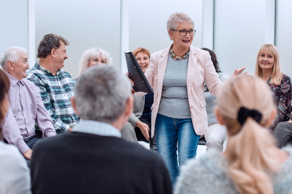 Ehrenamt für Rentner: ältere Dame unterrichtet Gruppe