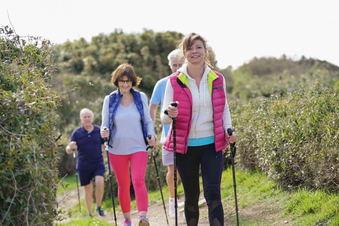 Gruppe von Senioren übt Nordic Walking aus