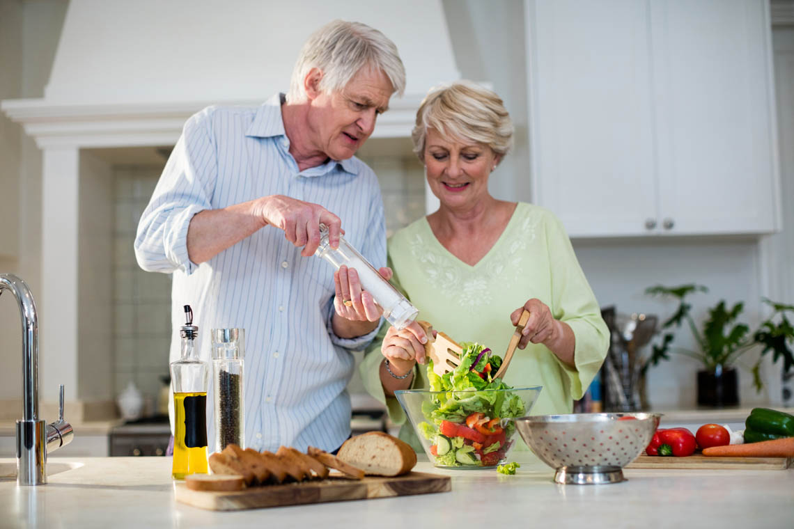 Älteres Paar bereitet Essen zu