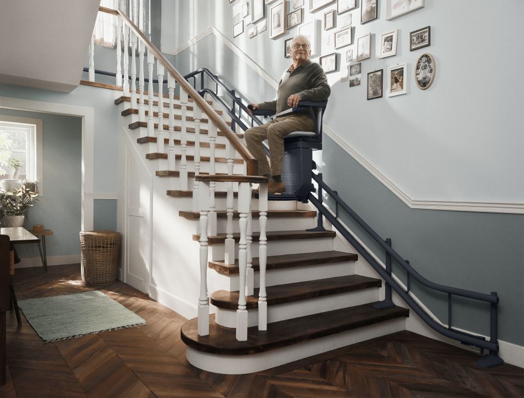 Hilfsangebote für Senioren: Ein Rentner nutzt einen Treppenlift in seinem Zuhause