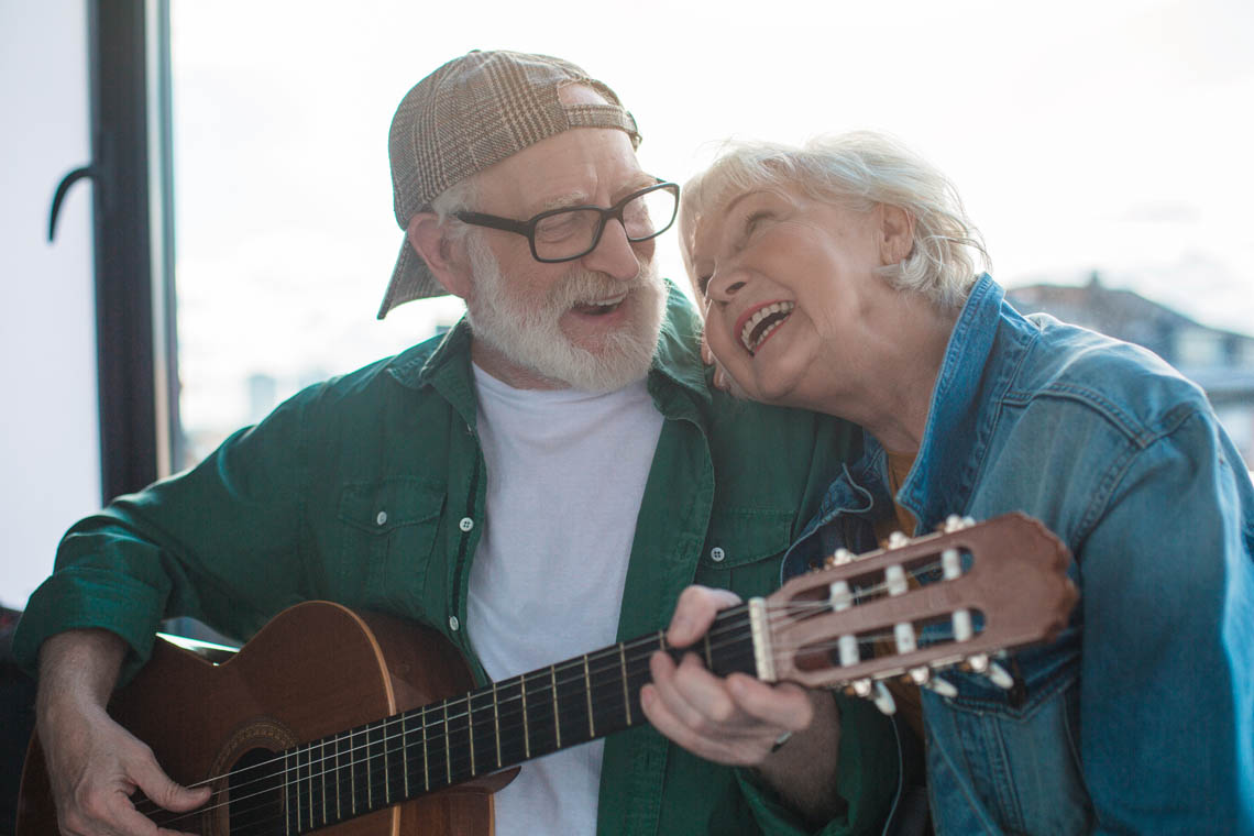 Älteres Paar singt und spielt Gitarre