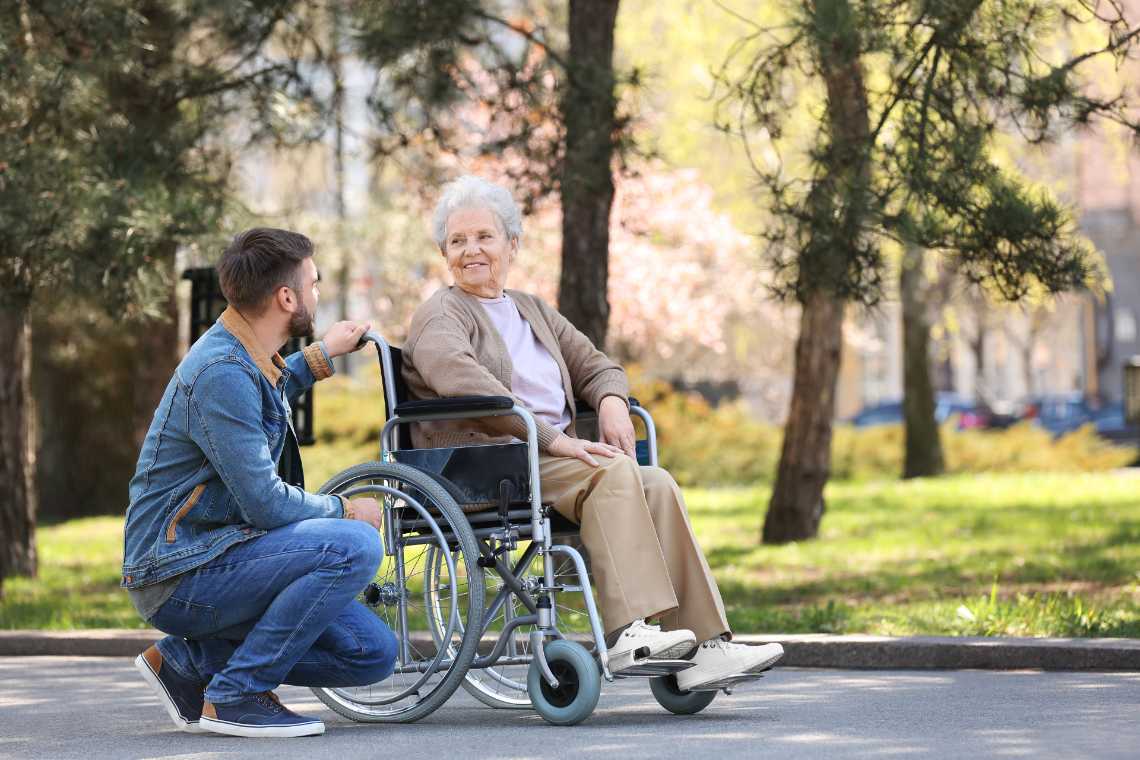 Pflegegrade: Seniorin mit Pfleger im Park