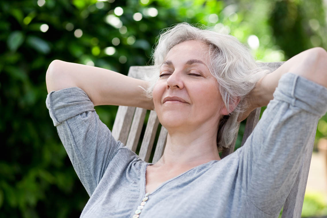 Seniorin entspannt auf Terrasse