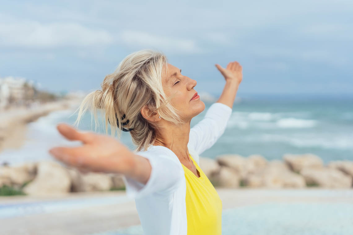 Meditierende Frau am Strand