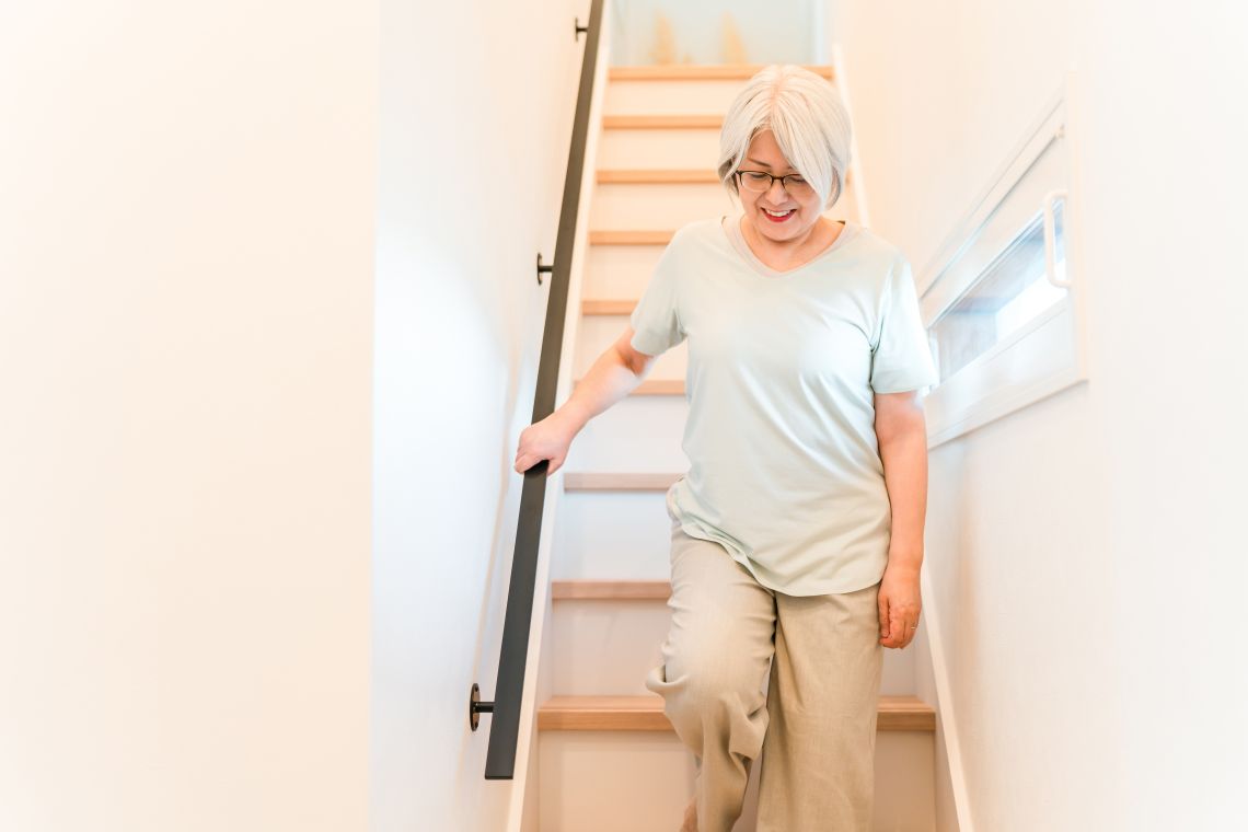 Eine Seniorin steigt ohne Probleme die Treppe hinab