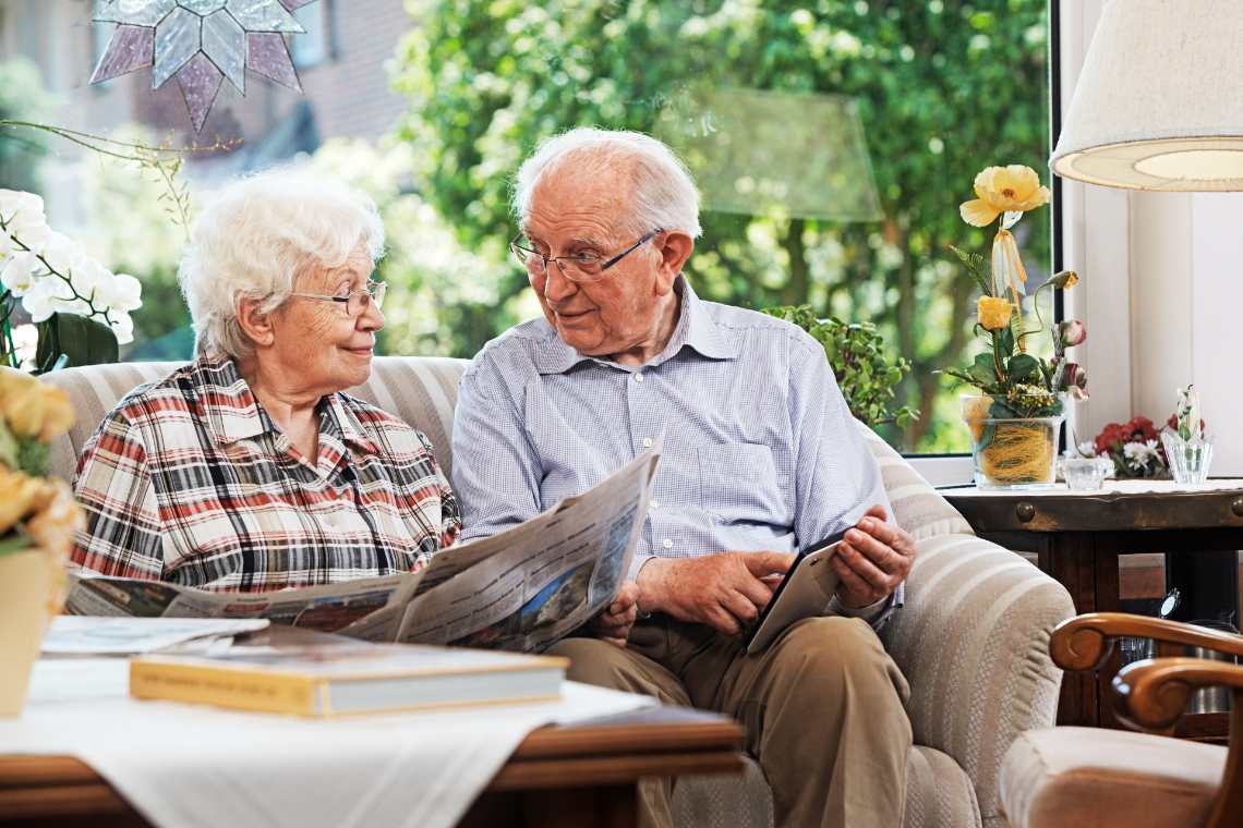 Seniorenpaar sitzt auf dem Sofa und schaut sich an