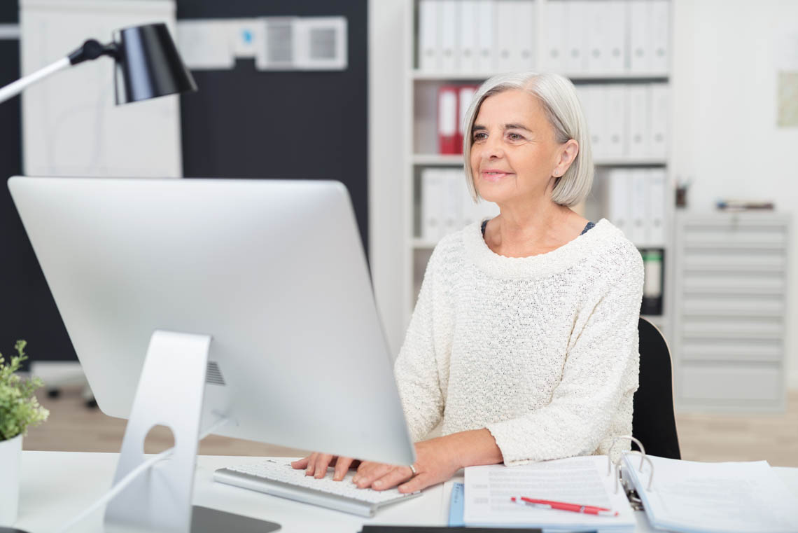 Seniorin arbeitet in Büro