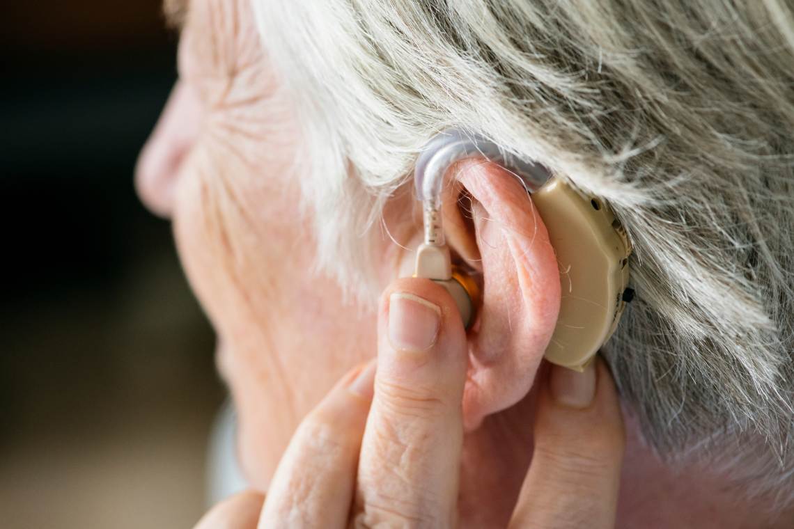 Nahaufnahme einer alten Frau mit Hörgerät im Ohr