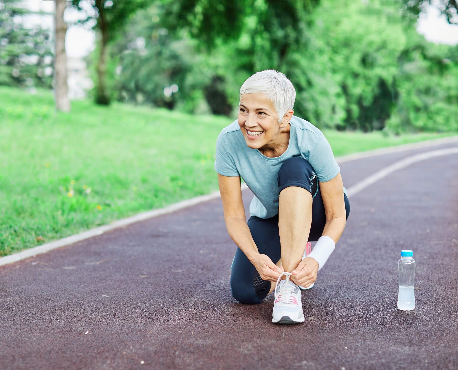 Frau zieht Laufschuhe fürs Slow Jogging an