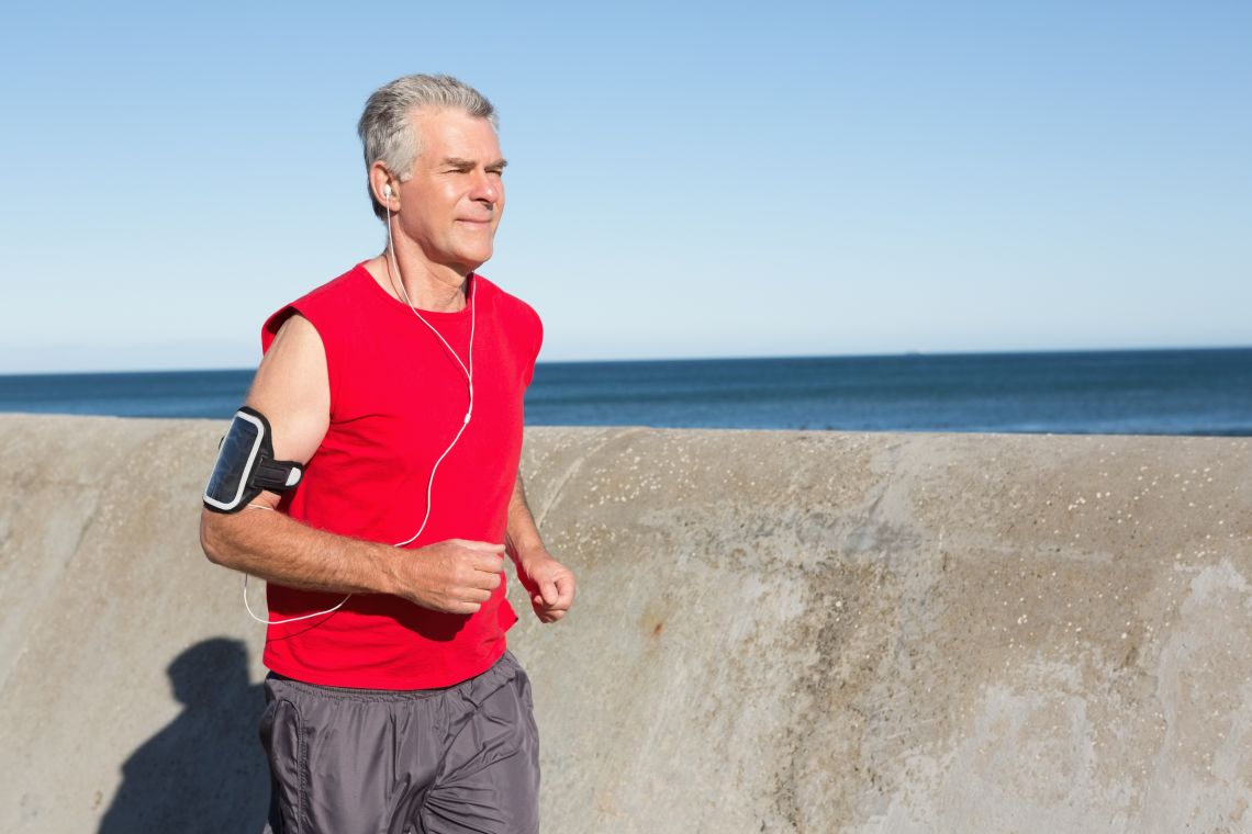 Ein älterer Mann joggt am Wasser entlang