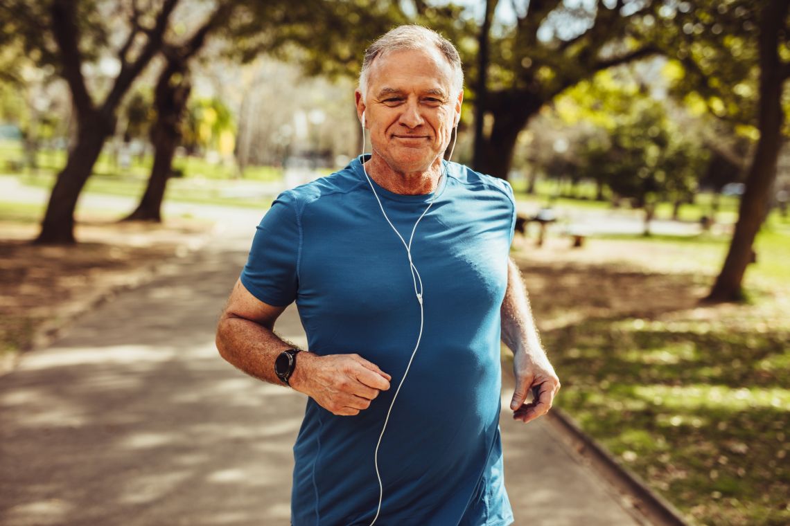 Ein Senior joggt entspannt durch den Park