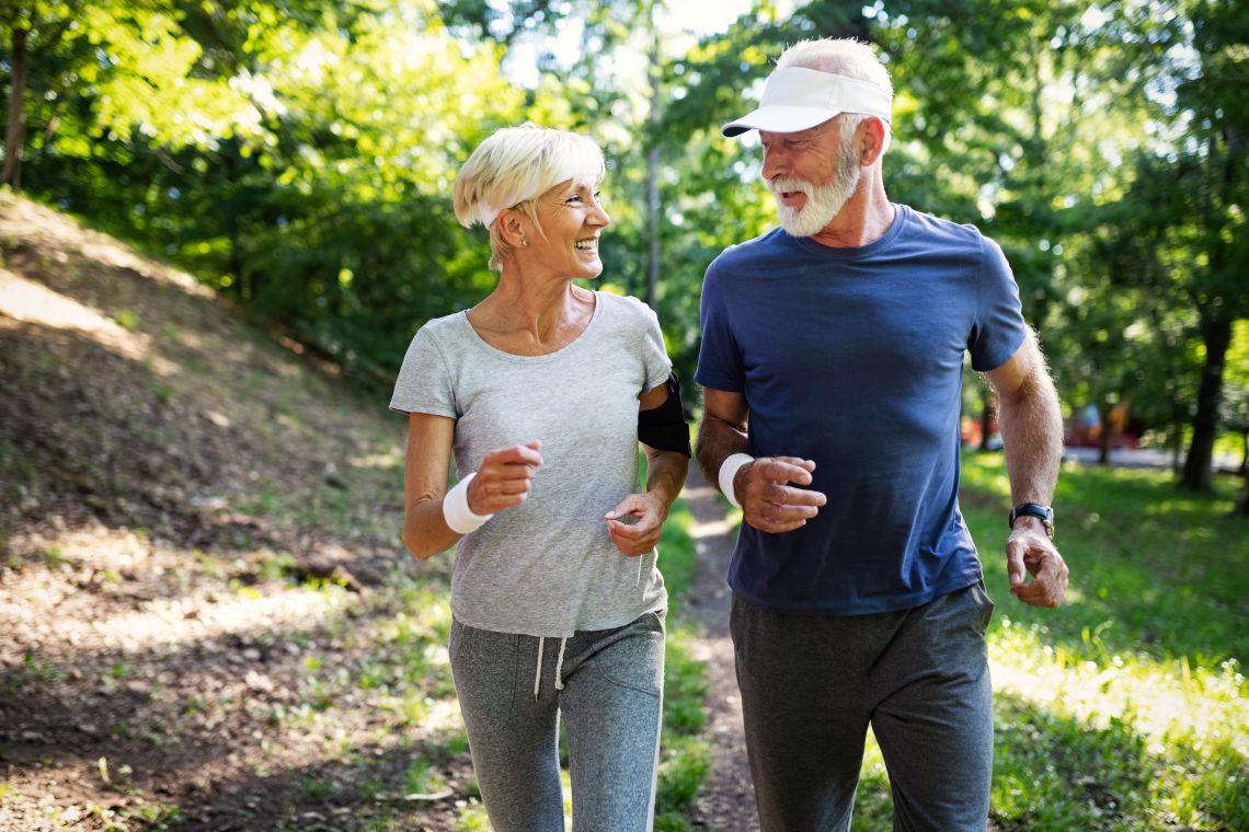 Ein älteres Paar joggt gemeinsam durch den Wald