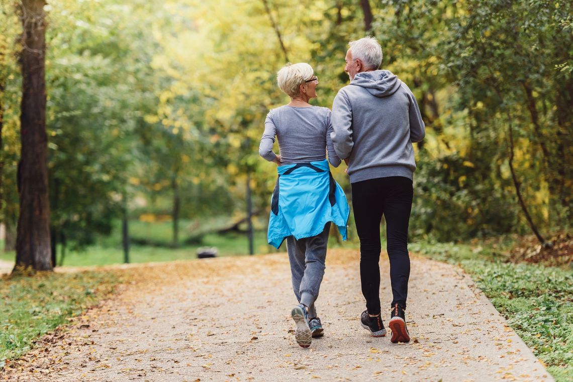 Älteres Paar joggt gemeinsam durch den Wald