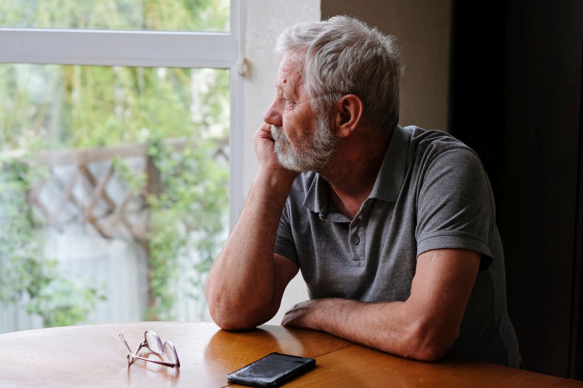 Sucht im Alter: Senior blickt aus Fenster