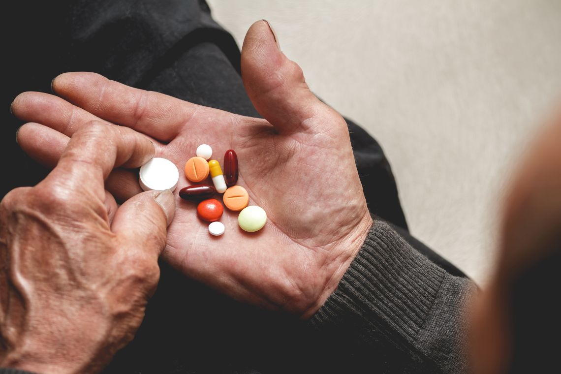 Sucht im Alter: Mann hält Tabletten in der Hand