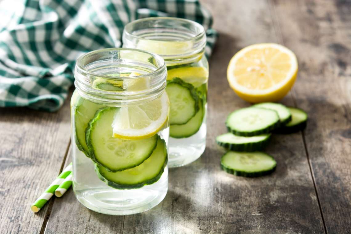 Leckere Getränke selber herstellen: Glas Wasser mit Gurkenscheiben und Zitrone