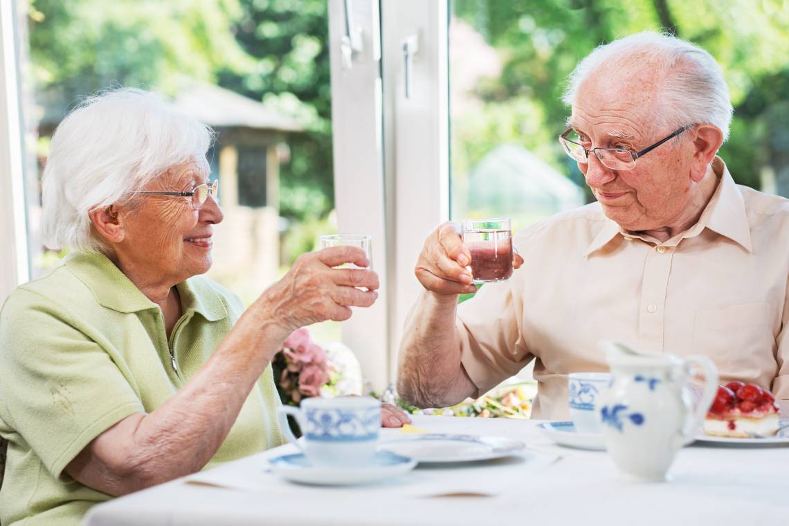 Zusammen trinken: Seniorenpaar stößt mit Wasser an