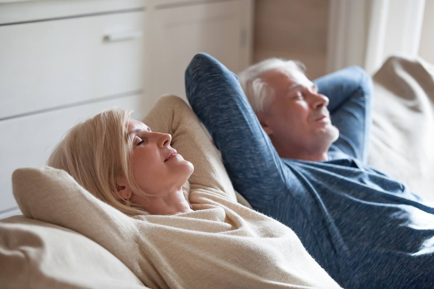 Älteres Paar entspannt sich auf der Couch im Urlaub zu Hause