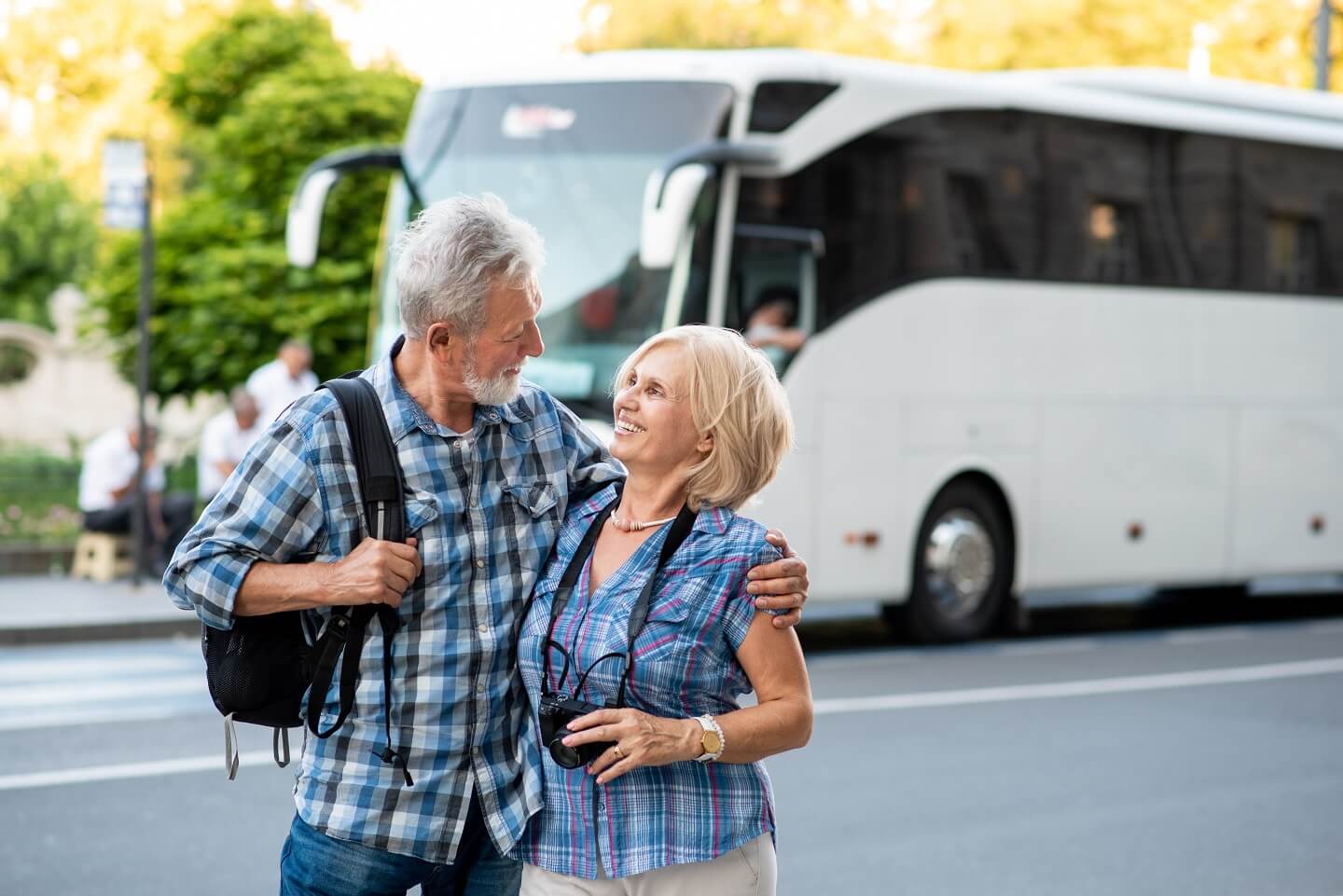 Älteres Paar vor einem Reisebus im Urlaub zu Hause