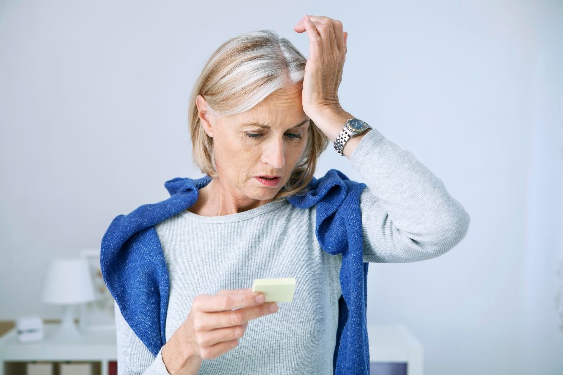 Frau hält sich Hand an die Stirn