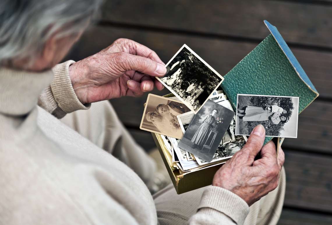 Frau schaut sich alte schwarz-weiß Fotos an
