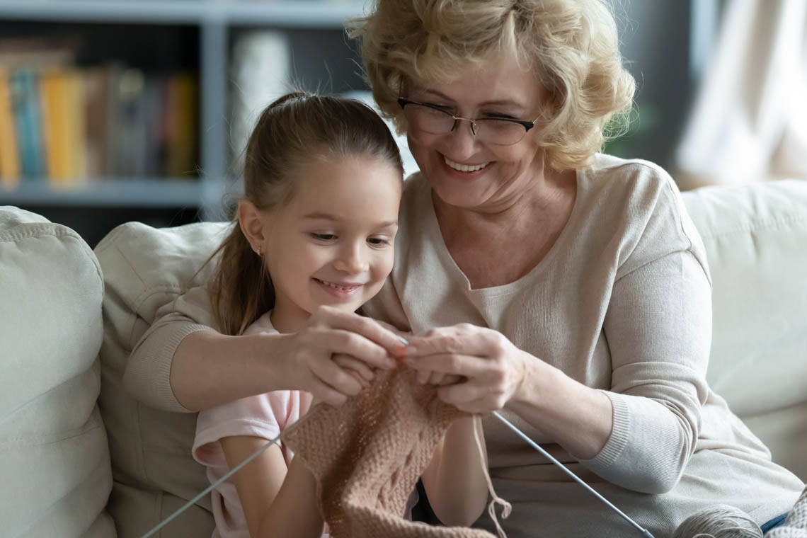 Seniorin mit Enkelin beim Stricken