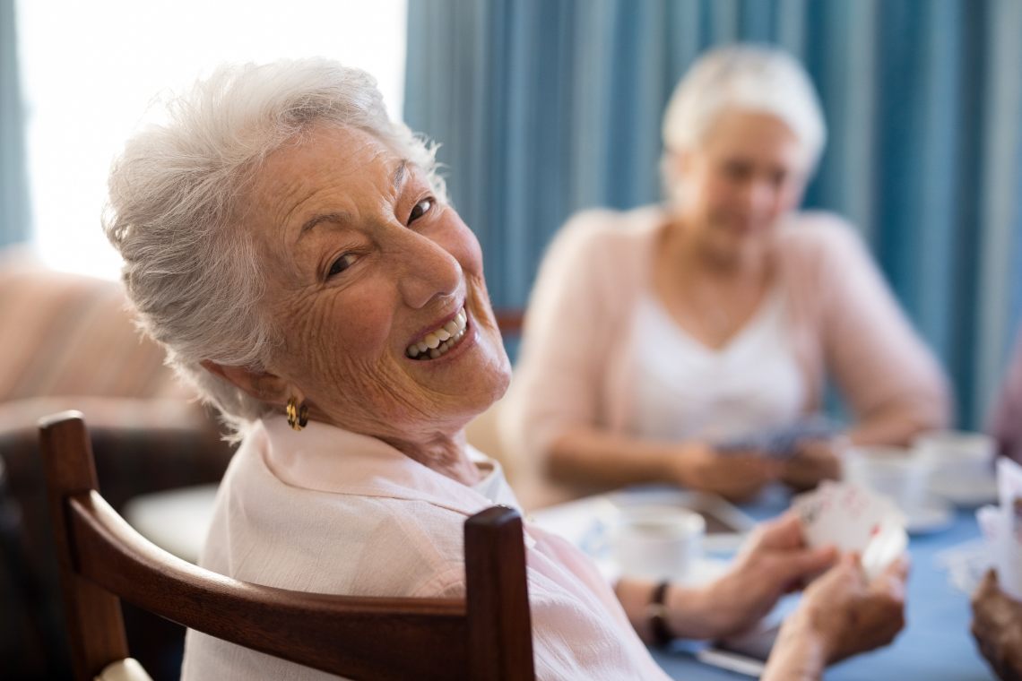 Ältere Frau beim Kartenspielen mit Freunden