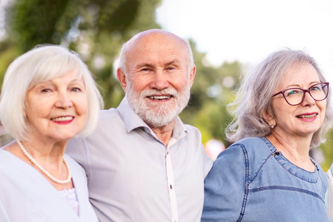 Drei Senioren lächeln in die Kamera