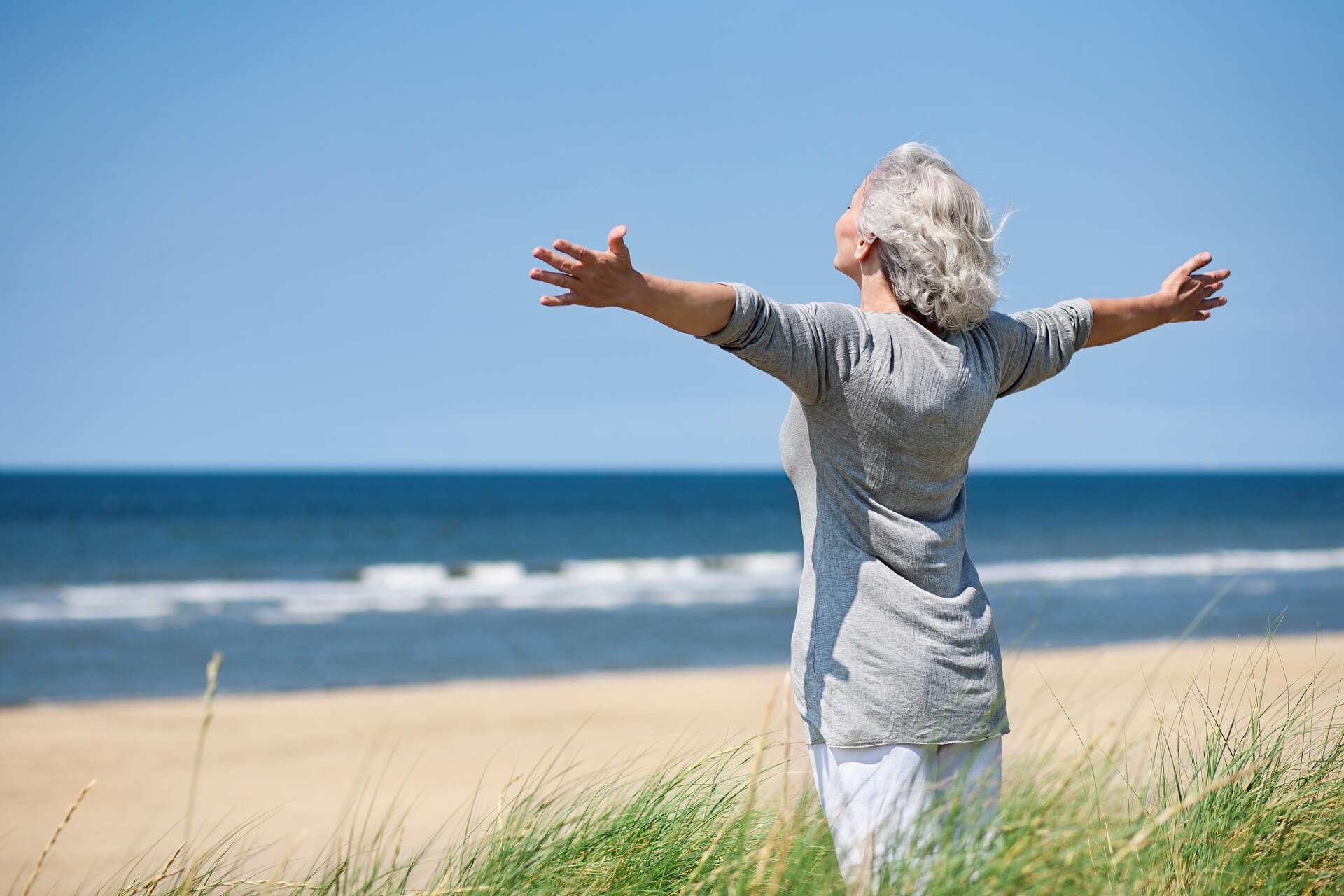 Wellness für Senioren: Ältere Frau erholt sich am Strand