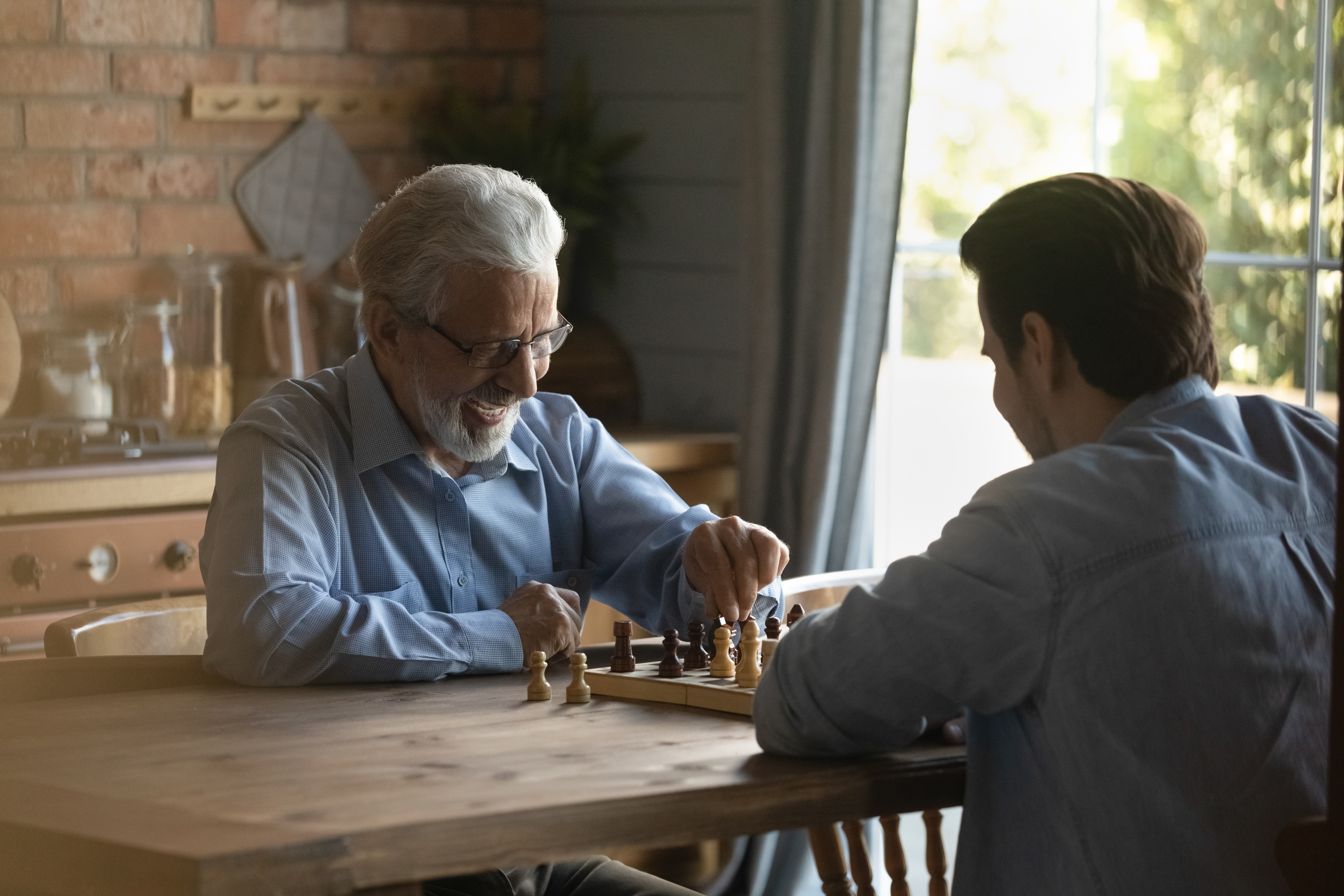 Ein alter und junger Mann spielen zusammen Schach