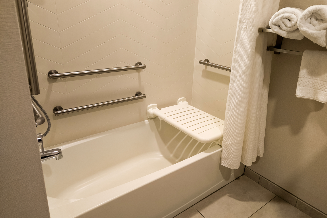 Barrierefreie Badewanne mit Haltegriffen und Duschsitz