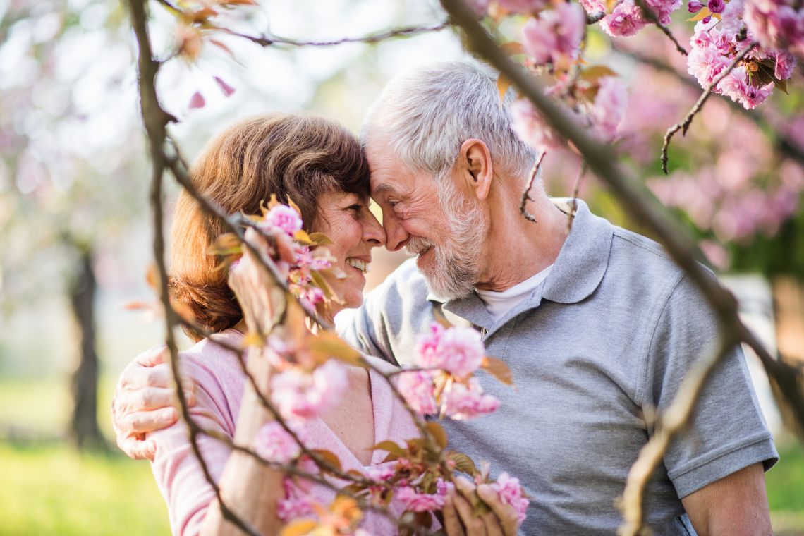 Seniorenpaar schaut sich draußen im Frühling verliebt an