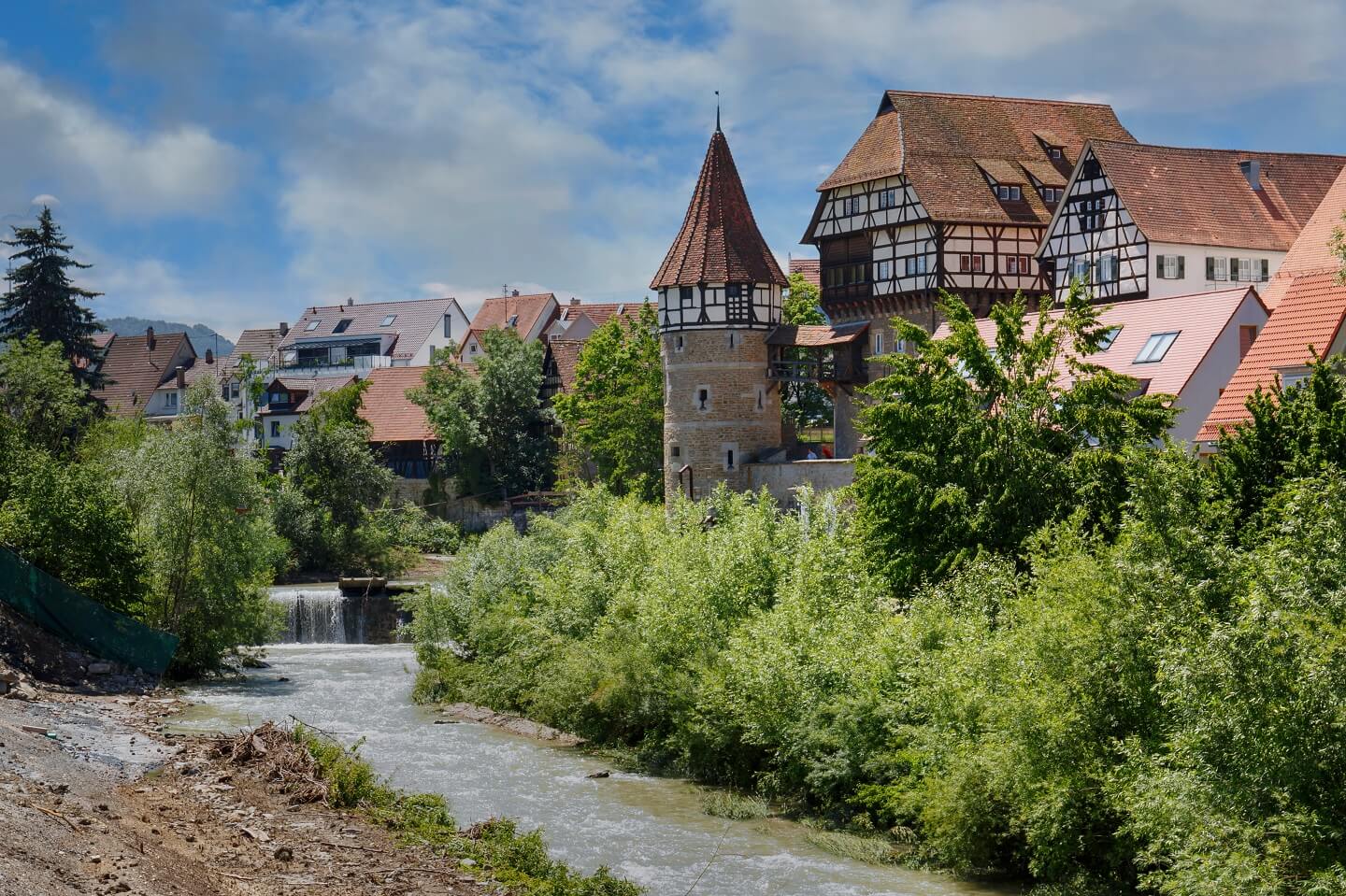 Fachwerkhäuser und historischer Turm vor einem Fluss in Balingen