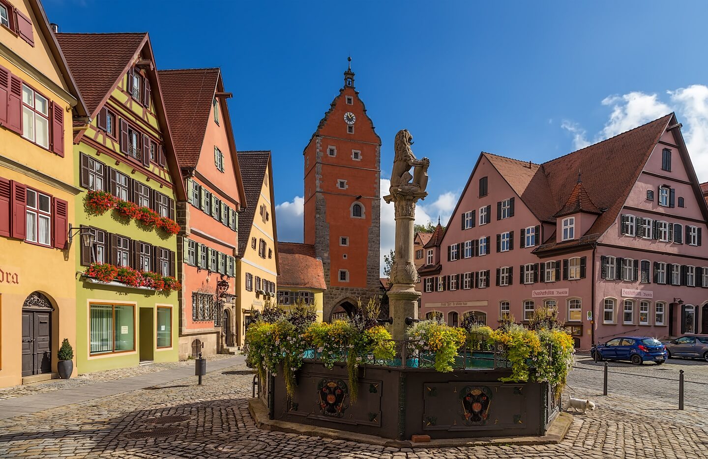 Stadttor, bunte Häuser und bewachsener Brunnen in Dinkelsbühl